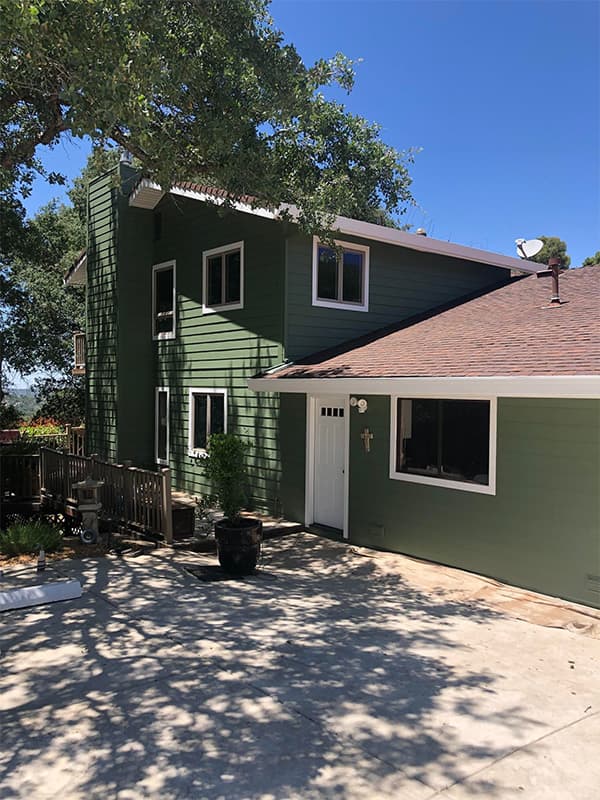 Exterior of a residential home painted forest green with white trim in El Dorado Hills, CA